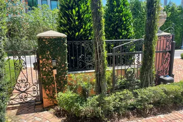 Ornamental steel fence and gate by a garden