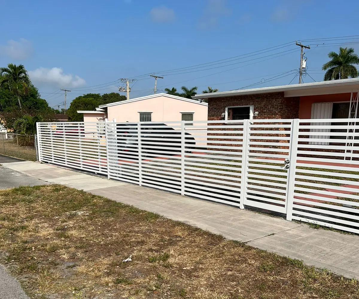 White horizontal slat aluminum fence along a South Florida home