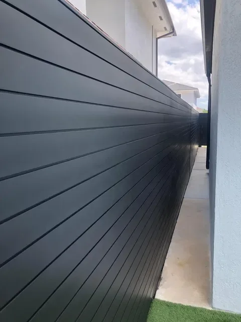 Black TG Fence aluminum privacy panels along a side yard